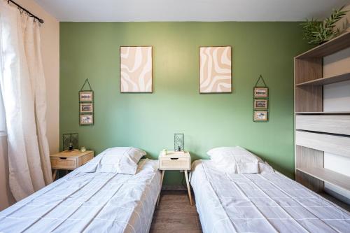 two beds in a room with green walls at Maison vélo et ski in Saint-Jean-de-Maurienne