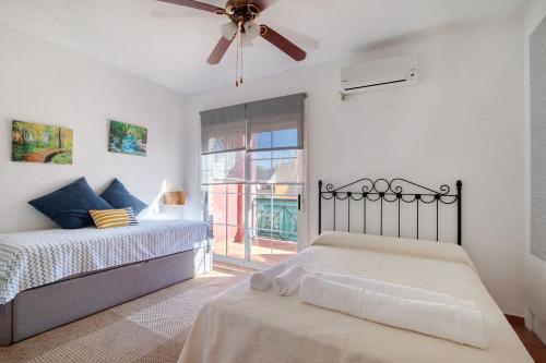 a bedroom with a bed and a ceiling fan at Duplex Luminoso Campo de Golf in Islantilla