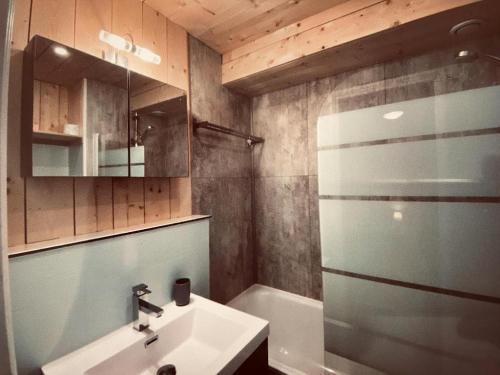 a bathroom with a sink and a shower and a mirror at Appartement Higginson Val Thorens in Val Thorens