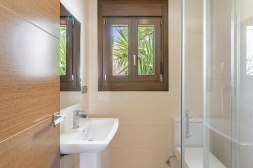 a bathroom with a sink and a toilet and a window at Chalet En La Cala De Mijas Costa in Mijas Costa