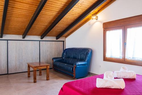 a living room with a blue leather chair and a table at Quercus in Navaluenga