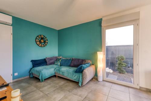 a living room with a couch and a clock on the wall at Chambre Villa illiade in Jacou