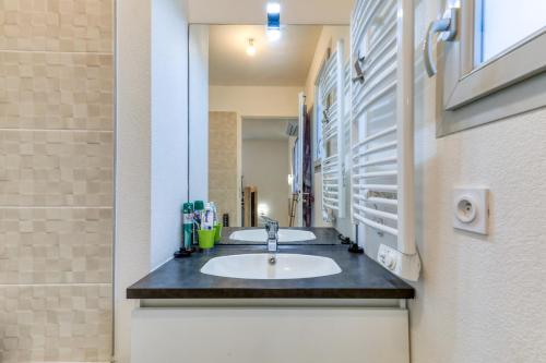 a bathroom with a sink and a mirror at Chambre Villa illiade in Jacou