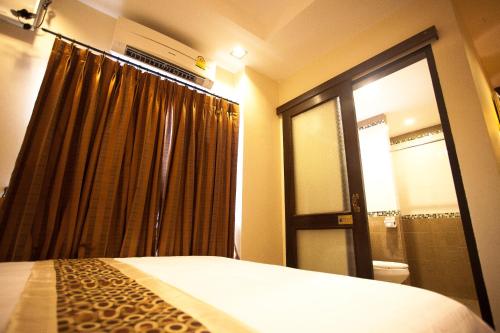 a bedroom with a bed and a window with a shower at At Home At Chiang Mai in Chiang Mai