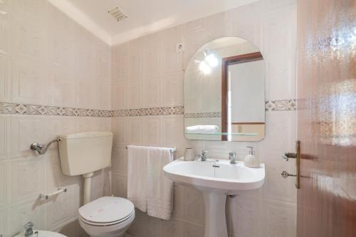 a white bathroom with a toilet and a sink at Casa Do Sol - Estombar Algarve in Estômbar