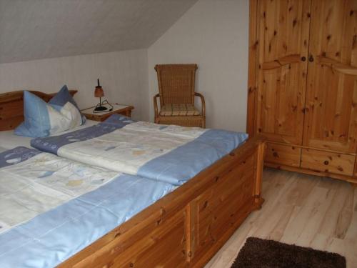 a bedroom with a large bed and a chair at Ferienwohnungen Ingrid Alfes in Ernestus