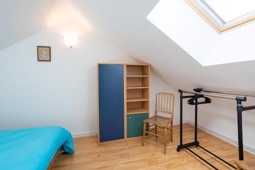 a bedroom with a blue cabinet and a chair at Au Fil Du Réguinier - Gîte Briançon in Briançon