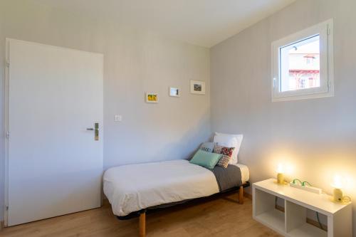 a small bedroom with a bed and a window at Chambre - Dorine in Aroue