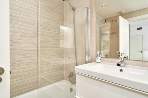 a bathroom with a white sink and a shower at Apartamento Playa Cabria in Almuñécar
