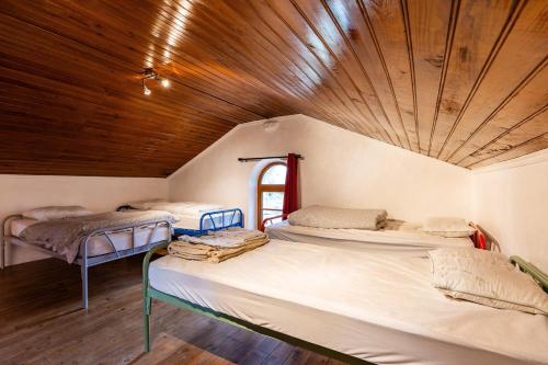 two beds in a room with a wooden ceiling at Gite de l'Ecluse in Bassanne