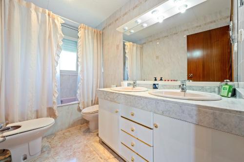 a bathroom with two sinks and a toilet at Casa Anglada in Calafell