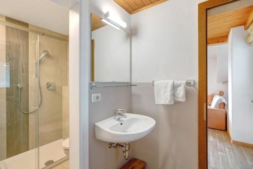 a white bathroom with a sink and a shower at Harmony Apt 1 in Appiano sulla Strada del Vino