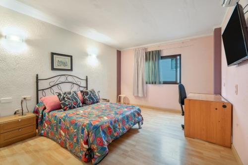 a bedroom with a bed and a dresser and a television at Casa Francisco in Granadilla de Abona