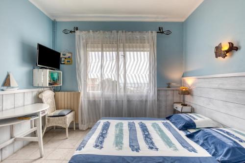 a bedroom with a bed and a desk and a window at Chambre d'hôtes - Le quartier haut in Sète