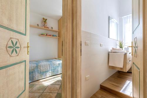 a small bedroom with a bed and a door at Villa Agnese 2- Penthouse- Seaview in Badesi