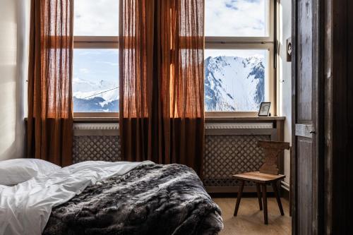a bedroom with a bed and a window with mountains at Chalet D'albiez in Albiez-Montrond