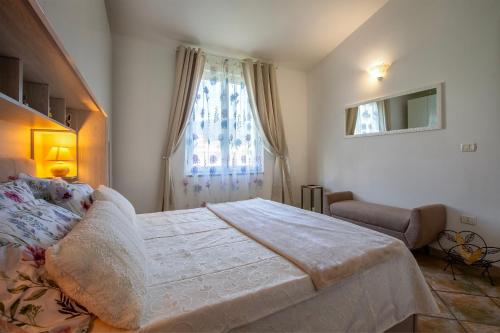a bedroom with a large bed and a window at Villa Agnese 2- Penthouse- Seaview in Badesi