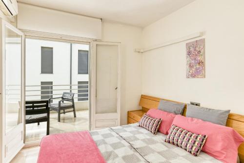 a bedroom with a bed with pink pillows and a table at Roses Sweet Home in Roses