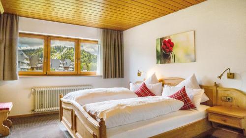 a bedroom with a bed with white sheets and pillows at Ferienhaus Unmüßig in Hinterzarten