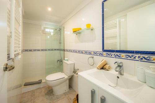 a white bathroom with a toilet and a sink at Can Picafort Sea Breeze in Can Picafort