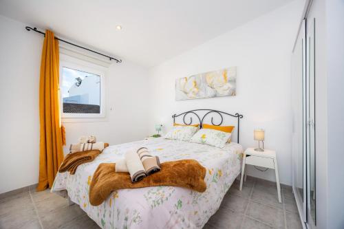 a bedroom with a bed with two towels on it at Can Picafort Sea Breeze in Can Picafort