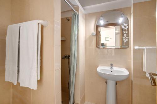 a bathroom with a sink and a mirror at Casa Ferrão in Armação de Pêra
