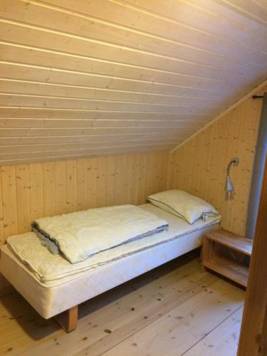 a bed in a room with a wooden ceiling at Sponavik Camping in Stord