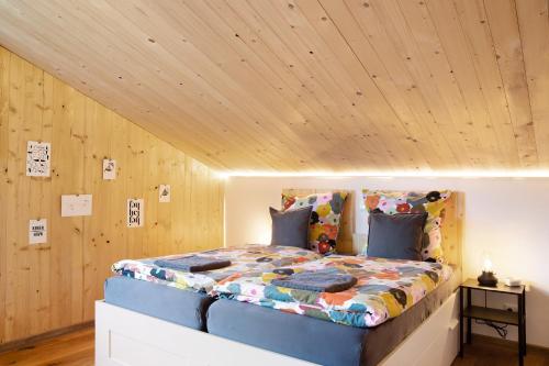 a bed in a room with a wooden ceiling at Refugium aus Vollholz in Schlitz