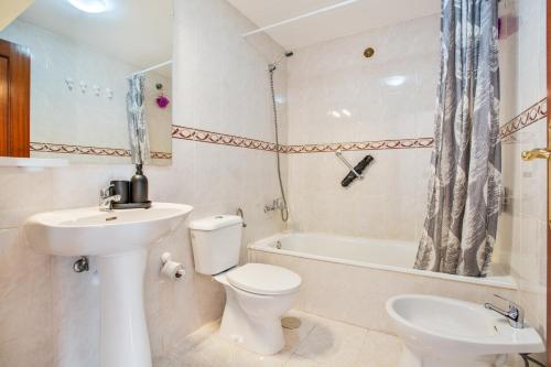 a bathroom with a toilet and a sink and a tub at Los Tinajones in La Oliva