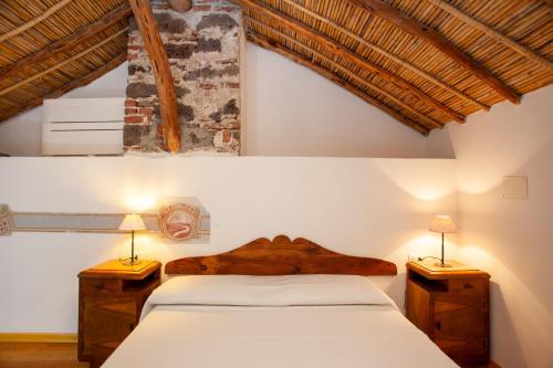 a bedroom with a bed and two lamps on tables at Hora Est in Orosei