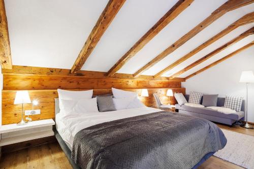 a bedroom with a large bed and a couch at Chalet Fluh in Oberstaufen