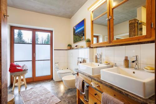 a bathroom with two sinks and a toilet at Chalet Fluh in Oberstaufen