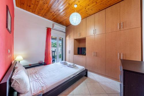a bedroom with a bed and wooden cabinets at Eli Guesthouse in Kavos