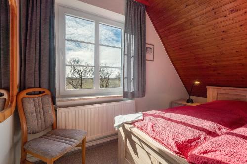a bedroom with a bed and a window and a chair at Fischerhus Anne Jensen in Pellworm
