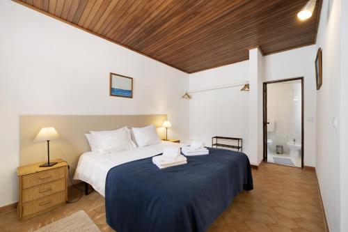 a bedroom with a large bed with a blue blanket at A Cerca - A in Lagos