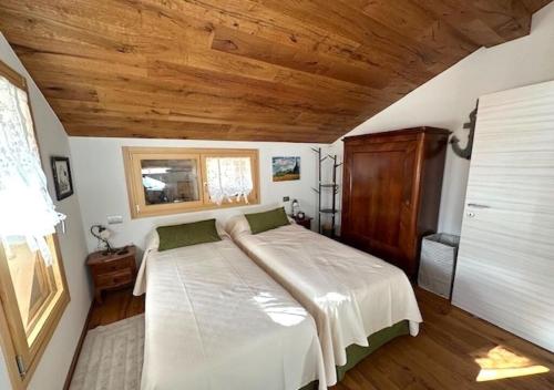 a bedroom with a bed and a wooden ceiling at Maso 1445,Quiet, Breathtaking Views in Siror