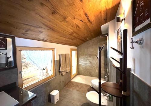 a bathroom with two toilets and a window at Maso 1445,Quiet, Breathtaking Views in Siror