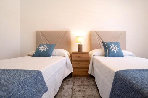 a bedroom with two beds with blue pillows at Casa Relax in Gran Tarajal