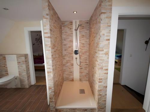 a bathroom with a shower in a brick wall at Ferienhaus Paula in Forbach