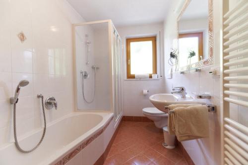 a bathroom with a tub and a toilet and a sink at Leitnerhof in Racines