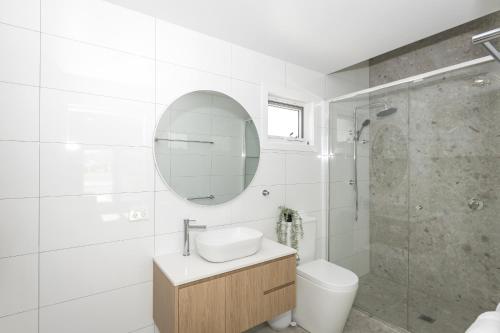 a white bathroom with a sink and a mirror at Marina 14 Harrington in Manning Point