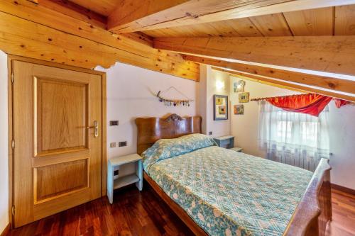 a bedroom with a bed and a wooden ceiling at Casa Montagna in Cadore in San Pietro di Cadore