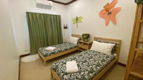 a room with two beds and a green curtain at Thailand Dream Village E09 in Klaeng