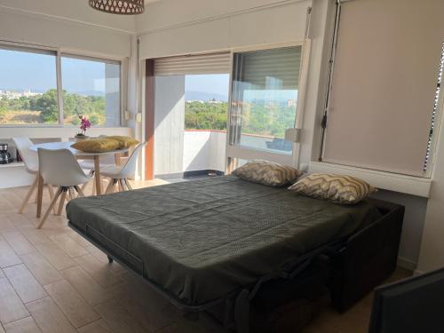a bedroom with a bed and a table with chairs at Sunset Studio in Alvor