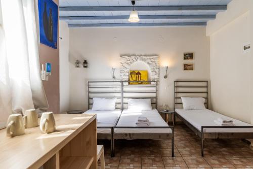 a room with two beds and a table at En Tino 2 in Tinos