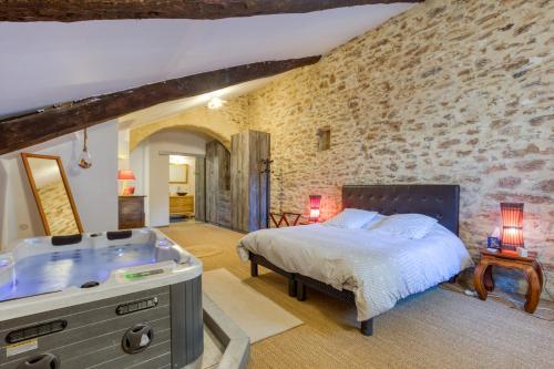 a bedroom with a bed and a bath tub at Forgerole in Faugères