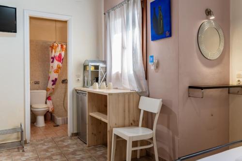 a bathroom with a sink and a toilet and a mirror at En Tino 2 in Tinos