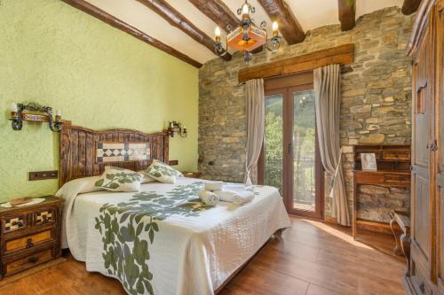 a bedroom with a bed and a stone wall at Casa Perico in Borrastre