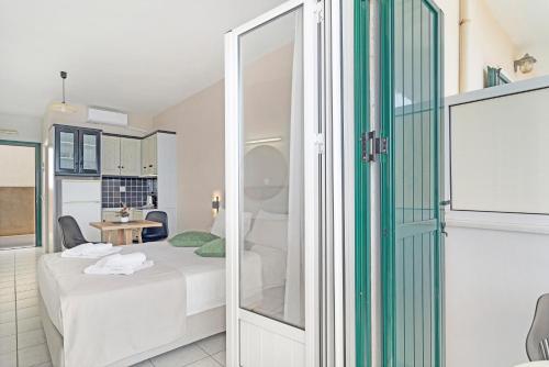 ein kleines Zimmer mit einem Bett und einer Glastür in der Unterkunft Sunset Premium Studio B in Lefkada Town