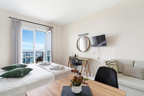 ein Schlafzimmer mit einem Bett, einem Tisch und einer Couch in der Unterkunft Sunset Premium Studio B in Lefkada Town